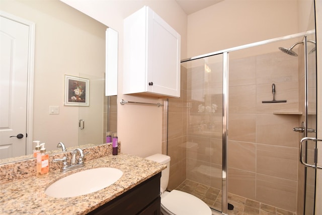 full bathroom featuring a shower stall, vanity, and toilet