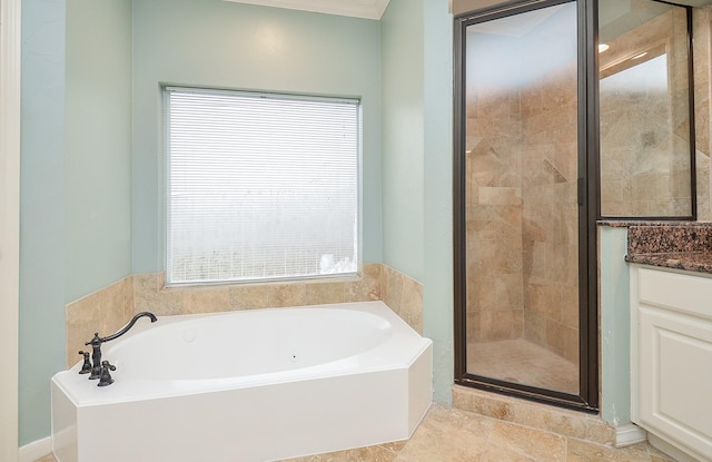 full bathroom with vanity, a bath, and a stall shower