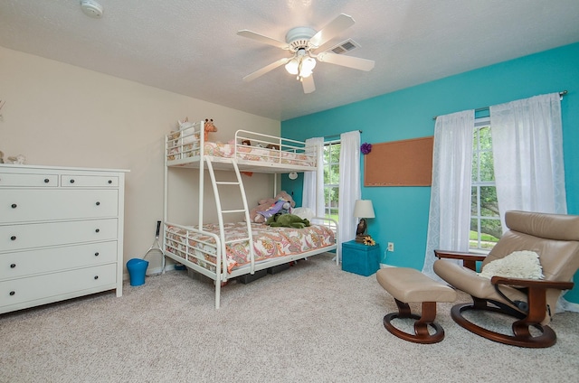 bedroom with visible vents, a ceiling fan, and carpet