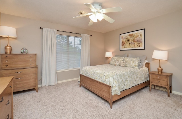 bedroom featuring baseboards, visible vents, a ceiling fan, and light colored carpet