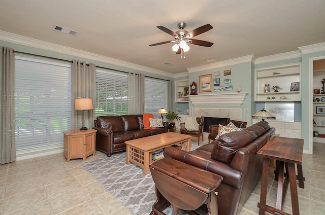 living area featuring ceiling fan, a fireplace, light tile patterned floors, visible vents, and ornamental molding