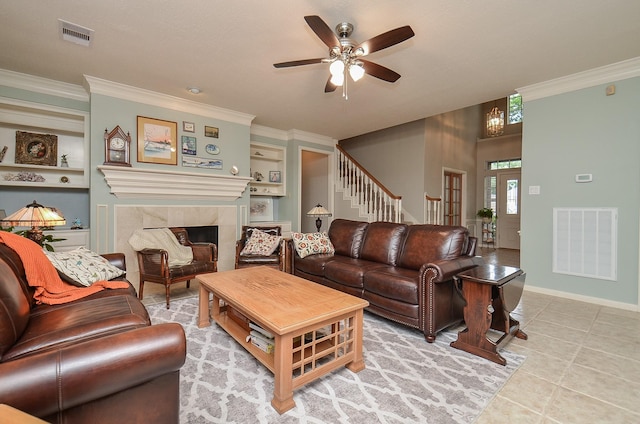 living area with crown molding, a ceiling fan, visible vents, and built in features