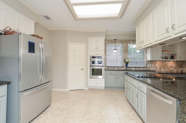 kitchen featuring visible vents, ornamental molding, white cabinetry, dark stone countertops, and appliances with stainless steel finishes