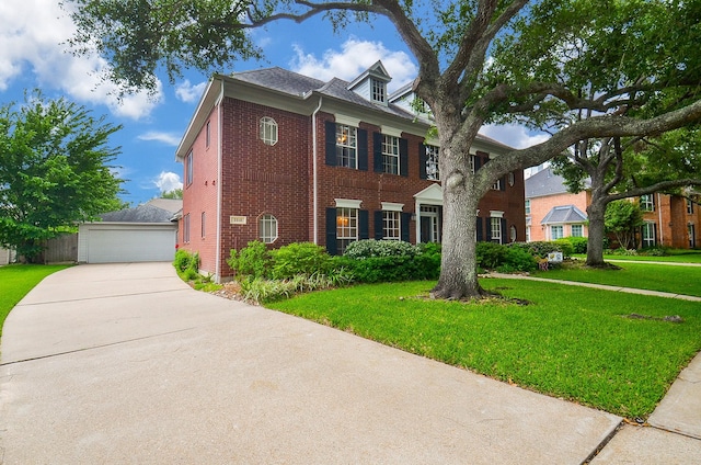 colonial-style house with a garage, a front lawn, and brick siding