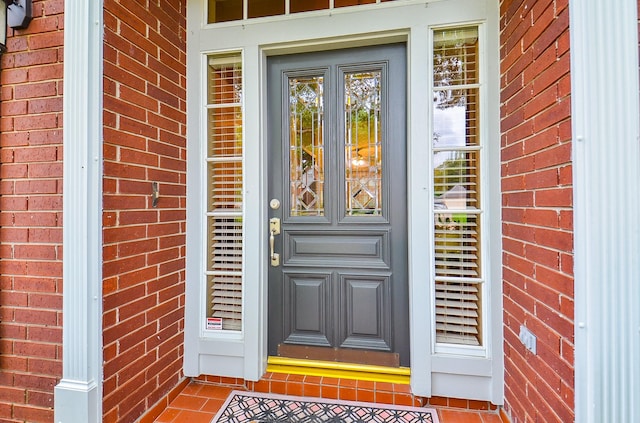 doorway to property with brick siding