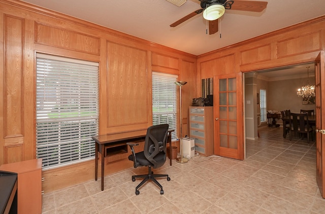 office area with crown molding, ceiling fan with notable chandelier, and wooden walls