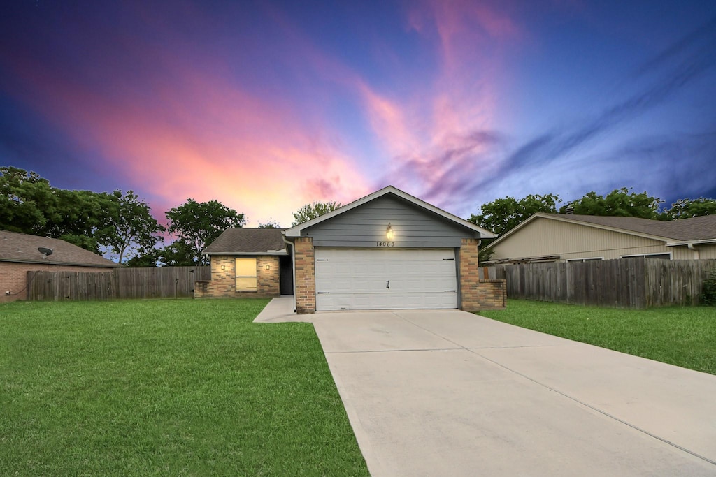 view of front facade with fence, a front lawn, brick siding, a garage, and concrete driveway