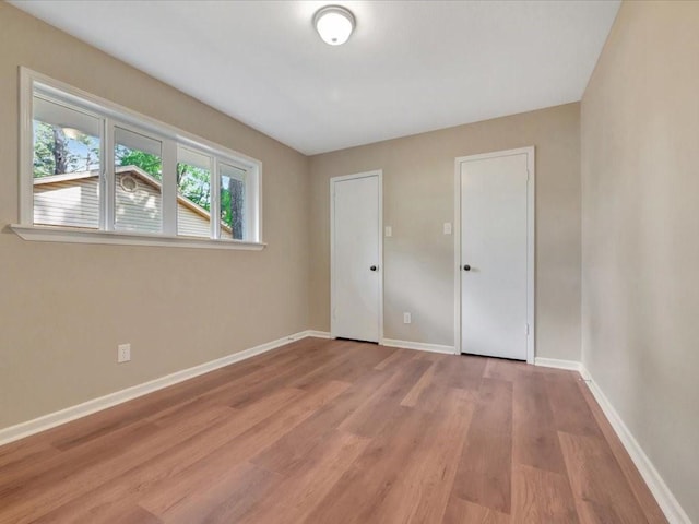 unfurnished bedroom with baseboards and light wood finished floors