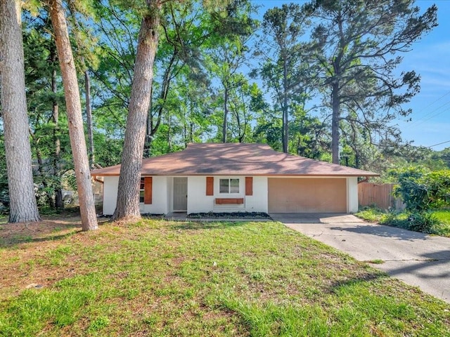 ranch-style house with fence, stucco siding, driveway, and a front yard