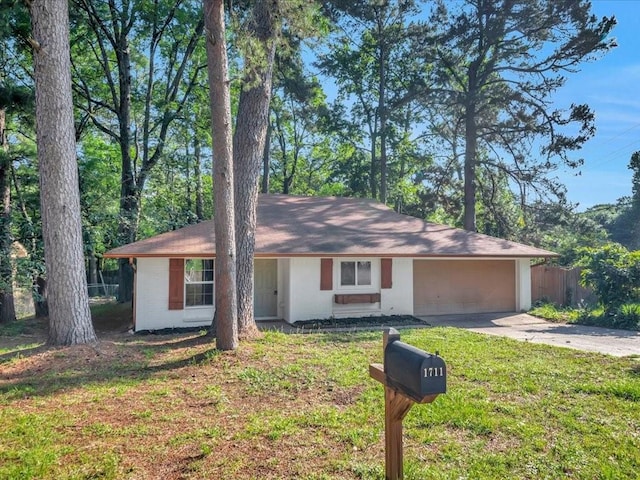 ranch-style home with a garage, fence, concrete driveway, and a front lawn
