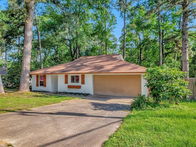 ranch-style home featuring an attached garage, stucco siding, driveway, and a front lawn