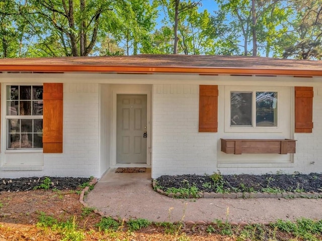 view of exterior entry featuring brick siding