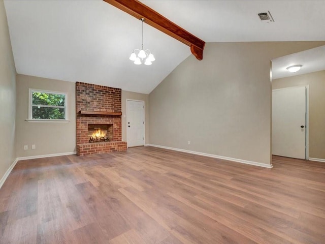 unfurnished living room featuring visible vents, a brick fireplace, wood finished floors, lofted ceiling with beams, and an inviting chandelier