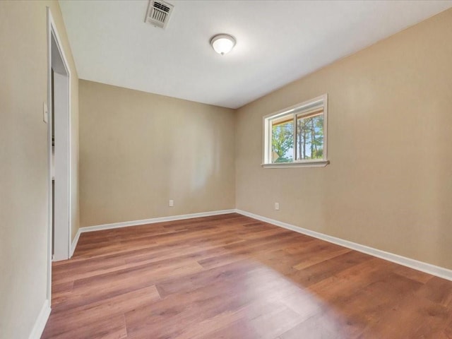 unfurnished bedroom featuring baseboards, wood finished floors, and visible vents