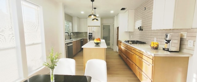 7619 Apache Plume Dr, Houston, TX 77071 - kitchen featuring stainless steel appliances, tasteful backsplash, a kitchen island, light countertops, and light wood finished floors