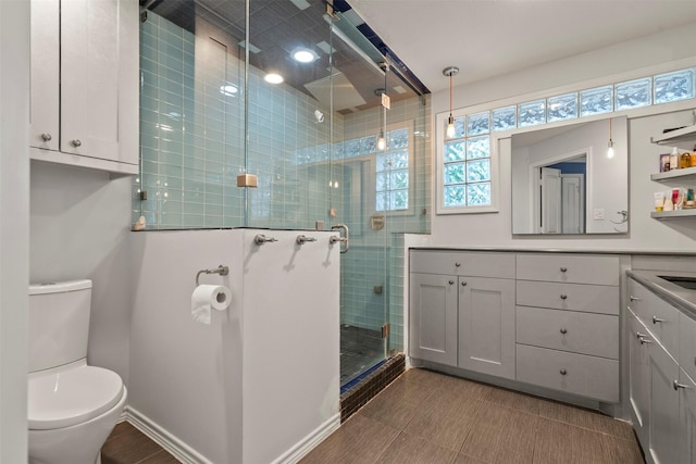 4811 Saxon St, Bellaire, TX 77401 - bathroom featuring vanity, baseboards, a stall shower, and toilet