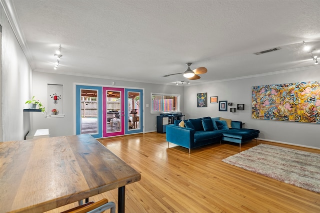4811 Saxon St, Bellaire, TX 77401 - living area featuring crown molding, a textured ceiling, a ceiling fan, wood finished floors, and visible vents