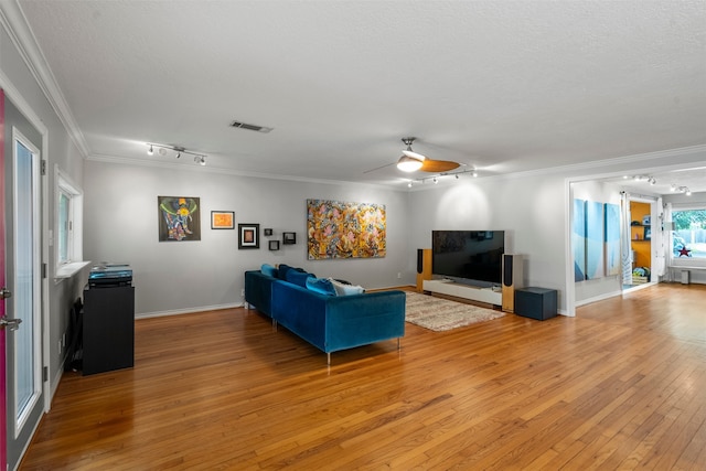 4811 Saxon St, Bellaire, TX 77401 - living room with a ceiling fan, visible vents, rail lighting, light wood-style floors, and ornamental molding