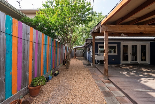 4811 Saxon St, Bellaire, TX 77401 - view of side of home featuring a ceiling fan, french doors, a fenced backyard, and a wooden deck