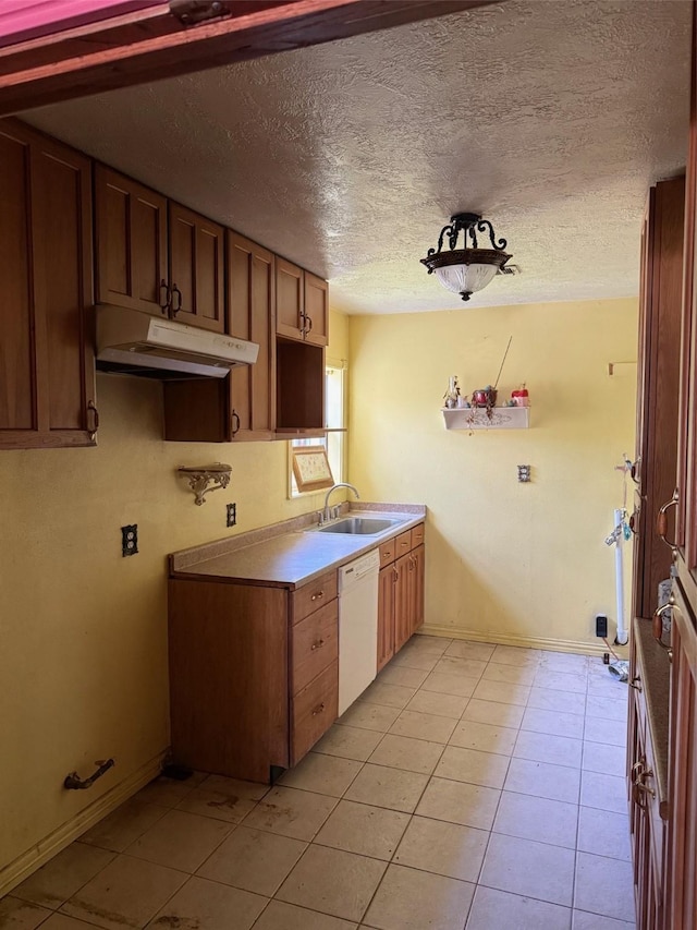 1130 Hoffman St, Houston, TX 77020 - kitchen with white dishwasher, a sink, under cabinet range hood, baseboards, and light tile patterned floors