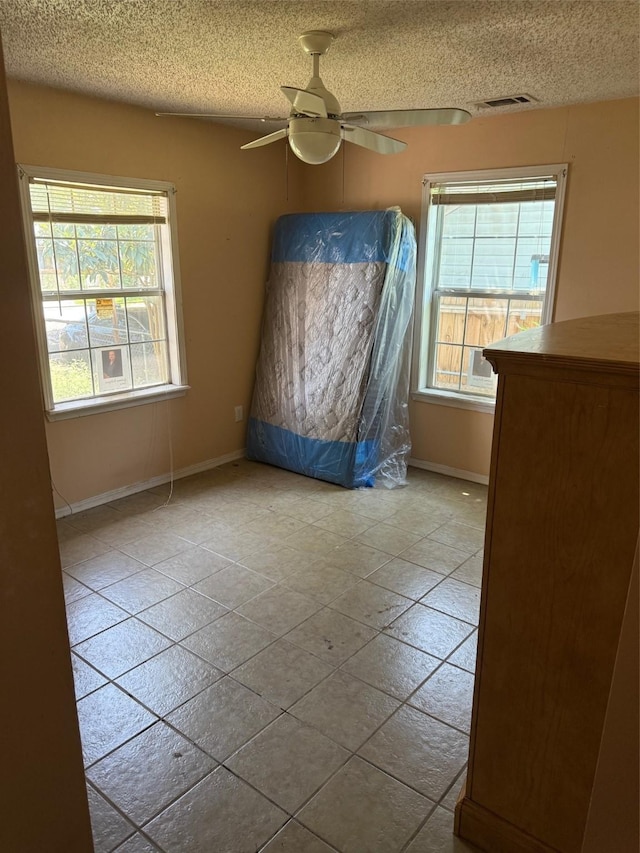 1130 Hoffman St, Houston, TX 77020 - bedroom with multiple windows, a textured ceiling, baseboards, and a ceiling fan