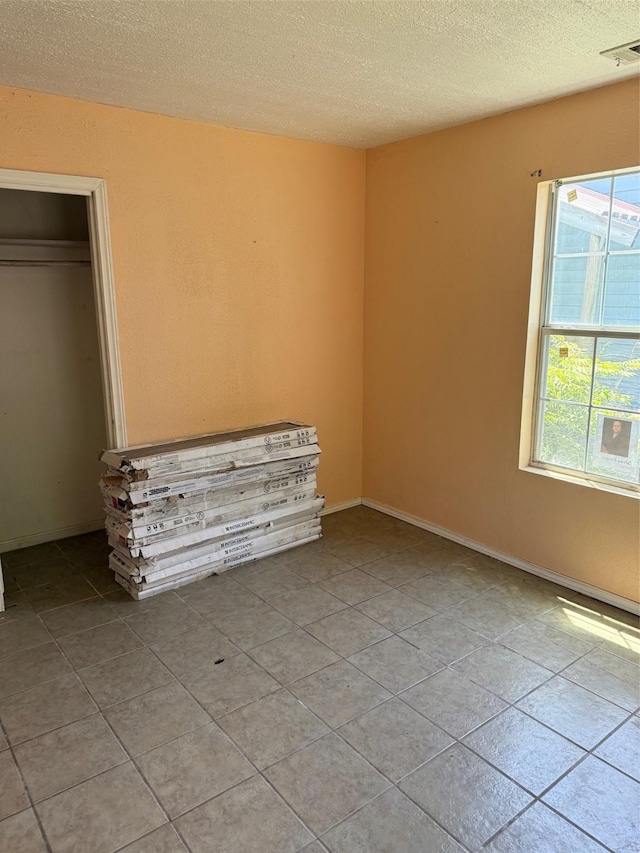 1130 Hoffman St, Houston, TX 77020 - unfurnished bedroom featuring a textured ceiling and light tile patterned floors