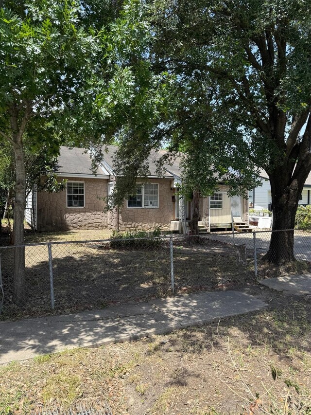 1130 Hoffman St, Houston, TX 77020 - view of property hidden behind natural elements featuring stone siding and a fenced front yard