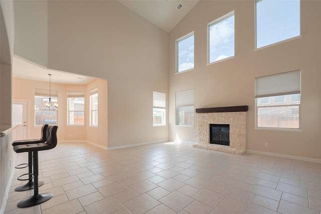 unfurnished living room featuring high vaulted ceiling, an inviting chandelier, and a fireplace