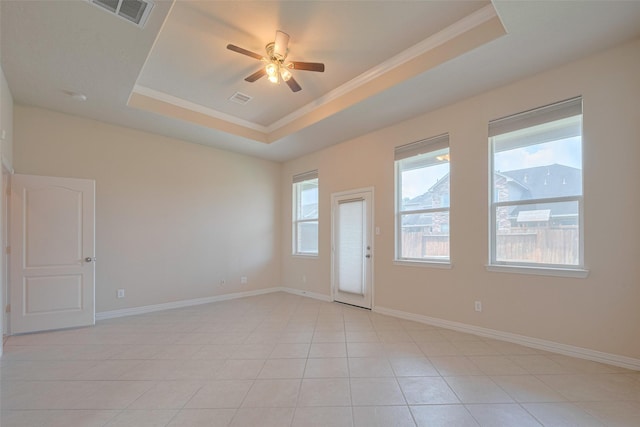 spare room with crown molding, ceiling fan, a tray ceiling, and visible vents