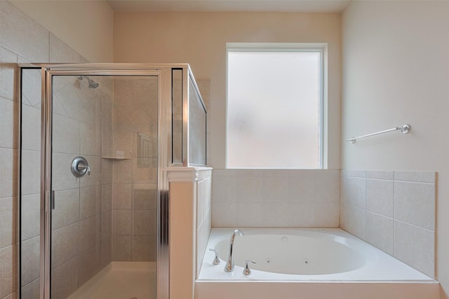 bathroom with a whirlpool tub, a shower stall, and a wealth of natural light