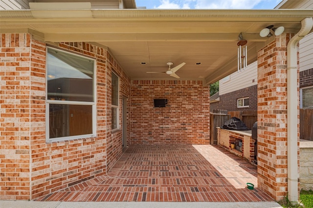 view of patio / terrace featuring area for grilling, fence, and a ceiling fan