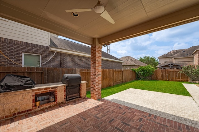 view of patio / terrace featuring a fenced backyard, a ceiling fan, exterior kitchen, and a grill