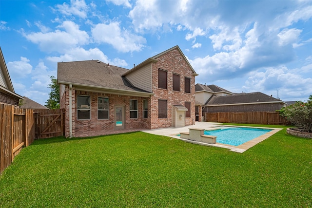 rear view of house featuring a fenced backyard, a yard, and brick siding