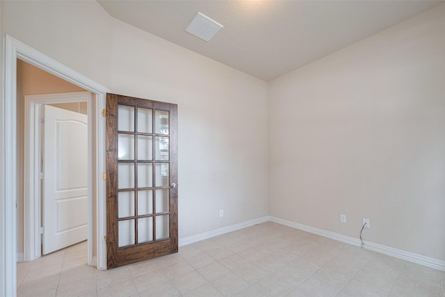 unfurnished room featuring visible vents, baseboards, light tile patterned floors, and vaulted ceiling