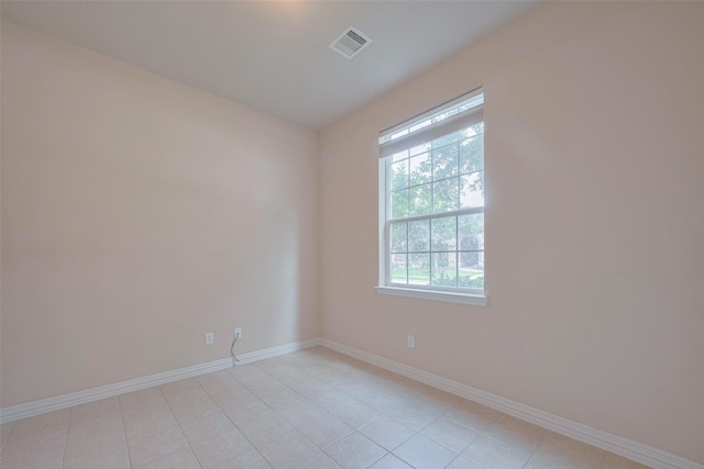 unfurnished room featuring light tile patterned floors, baseboards, visible vents, and a healthy amount of sunlight