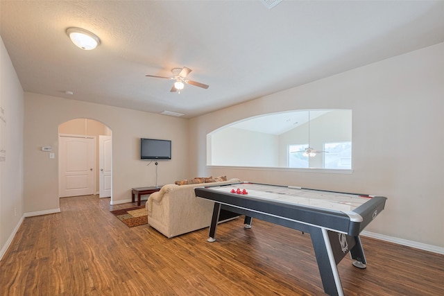 game room with arched walkways, ceiling fan, baseboards, and wood finished floors