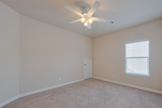 unfurnished room featuring a ceiling fan, baseboards, light colored carpet, and visible vents