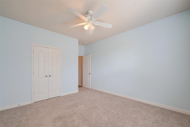 unfurnished bedroom featuring a closet, baseboards, ceiling fan, and light carpet
