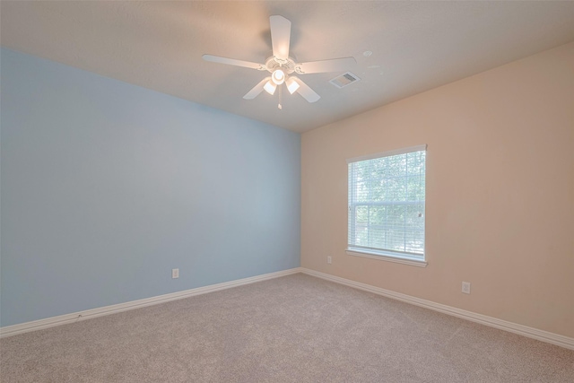 spare room featuring visible vents, a ceiling fan, baseboards, and light carpet