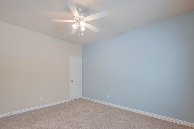 spare room with baseboards, light carpet, and a ceiling fan