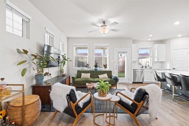 living area with recessed lighting, ceiling fan, and light wood-style flooring