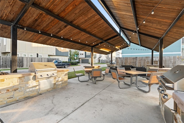 view of patio / terrace with fence, grilling area, and an outdoor kitchen