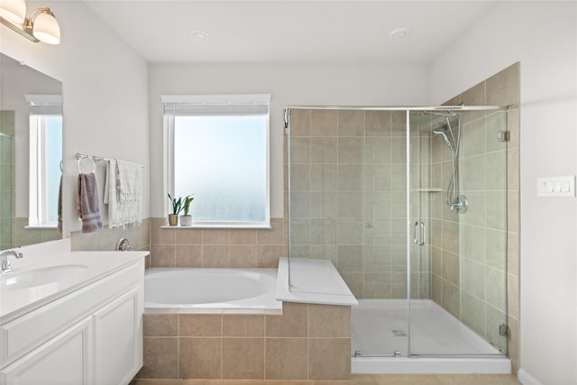 full bathroom featuring a garden tub, vanity, and a shower stall