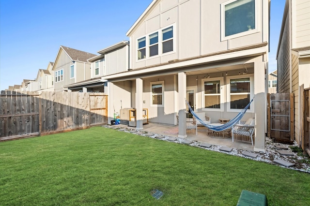 back of property with a patio, a fenced backyard, a lawn, and a residential view