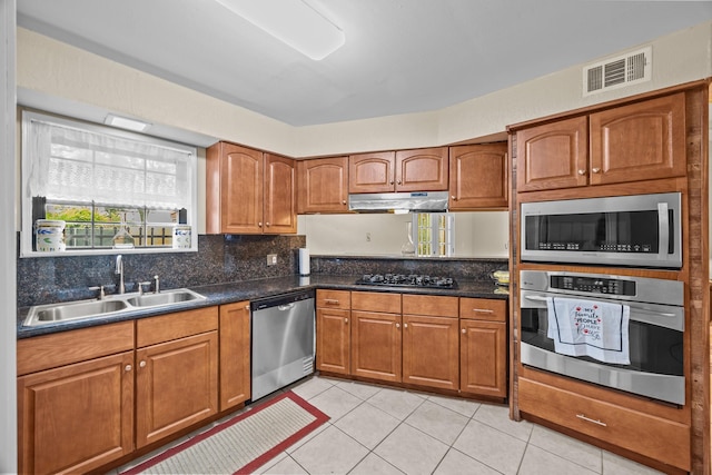 2234 Kelly Dr, Pearland, TX 77581 - kitchen with appliances with stainless steel finishes, a sink, brown cabinets, and dark countertops