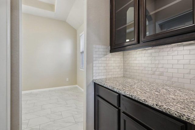 4310 Treccia Ct, Katy, TX 77493 - kitchen with light marble finish floors, light stone countertops, baseboards, tasteful backsplash, and dark brown cabinetry