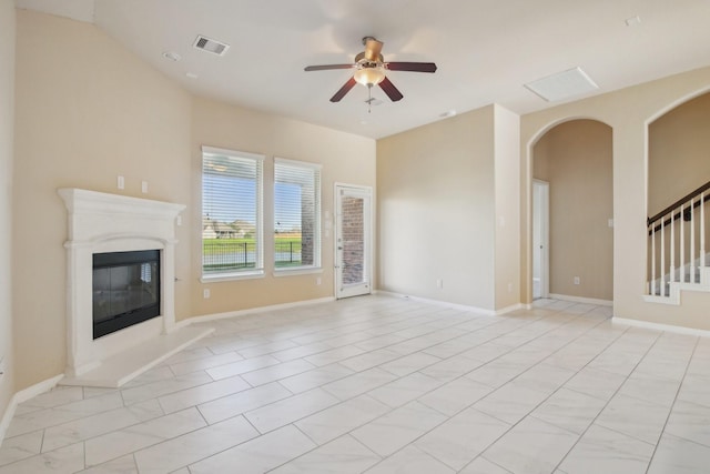 4310 Treccia Ct, Katy, TX 77493 - unfurnished living room with ceiling fan, a high end fireplace, stairs, arched walkways, and baseboards