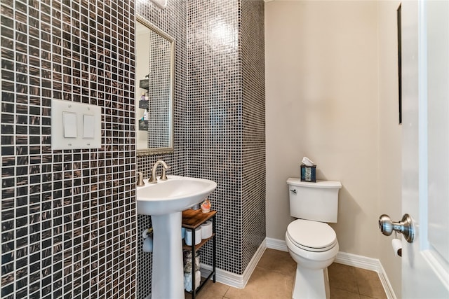 bathroom featuring tile walls, tile patterned flooring, and toilet