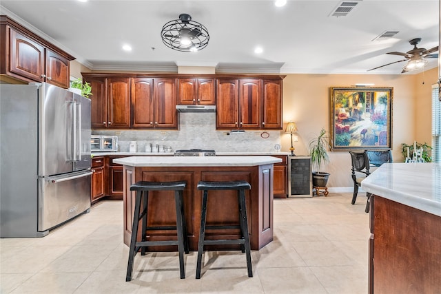 kitchen with high end refrigerator, light countertops, beverage cooler, and visible vents