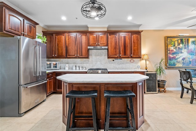 kitchen featuring crown molding, tasteful backsplash, high quality fridge, and range